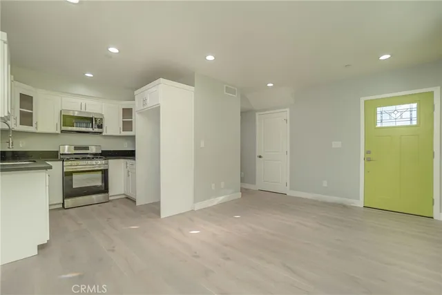 a view of kitchen with cabinets microwave and stove