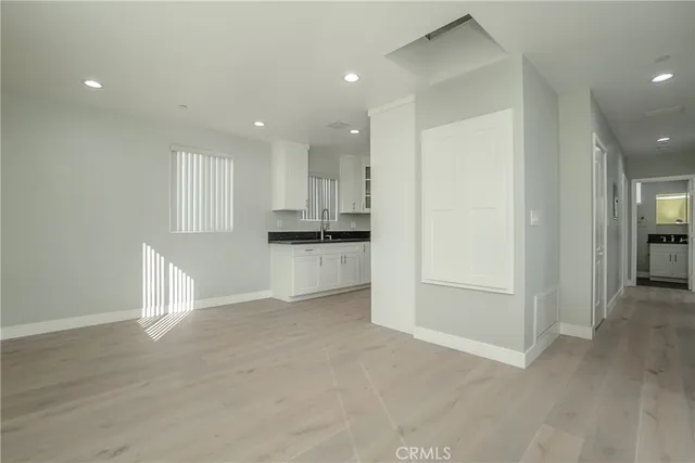 a view of empty room with wooden floor and cabinets