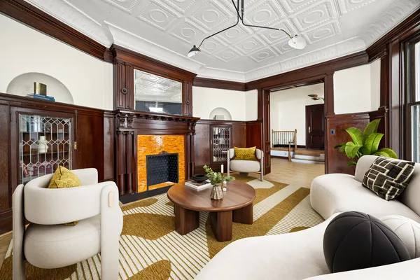 a living room with furniture a fireplace and a chandelier