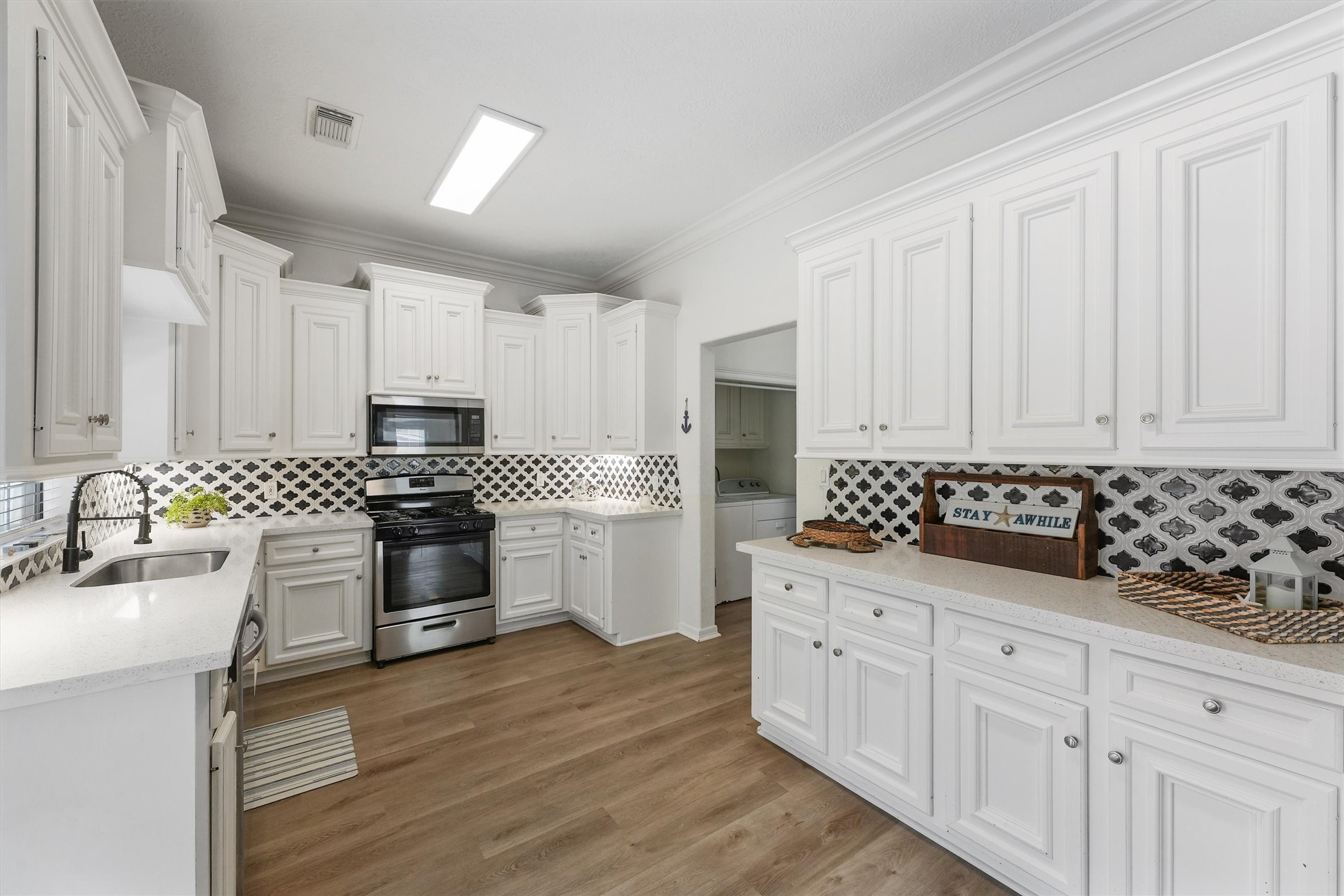 3024 Avenue R 1/2 Galveston, TX 77550 - Photo 4 of 28 a kitchen with white cabinets and appliances