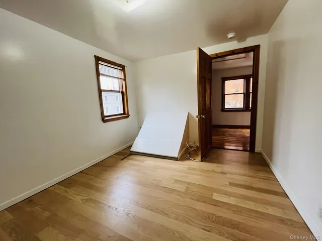 an empty room with wooden floor and window