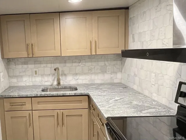 a kitchen with granite countertop white cabinets and a sink