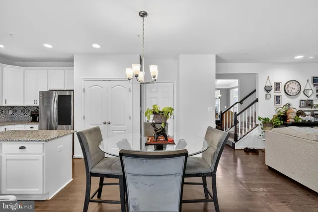 a dining room with furniture a chandelier and wooden floor