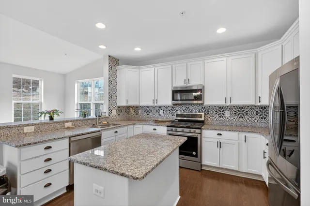 a kitchen with cabinets appliances a sink and a counter top space