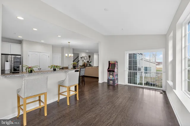a kitchen with stainless steel appliances a dining table chairs and wooden floor