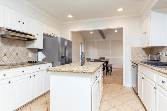 a kitchen with stainless steel appliances granite countertop a sink and a refrigerator