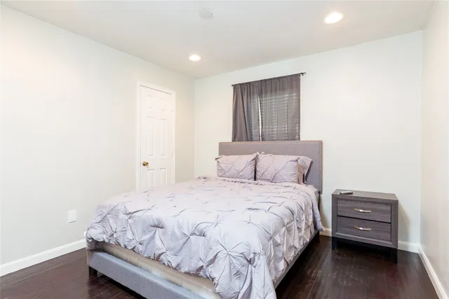 a bed sitting in a spacious bedroom next to a window