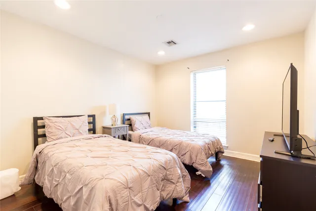 a spacious bedroom with two beds and a desk