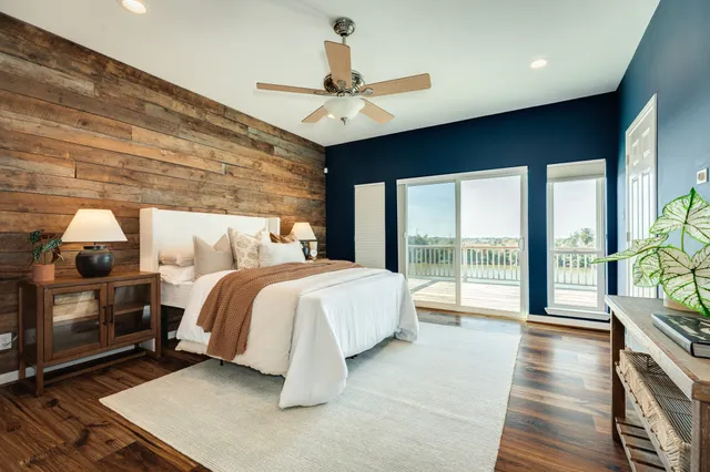 a spacious bedroom with a balcony a bed and large window