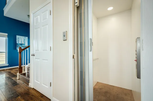 a view of a hallway with wooden floor and dining room