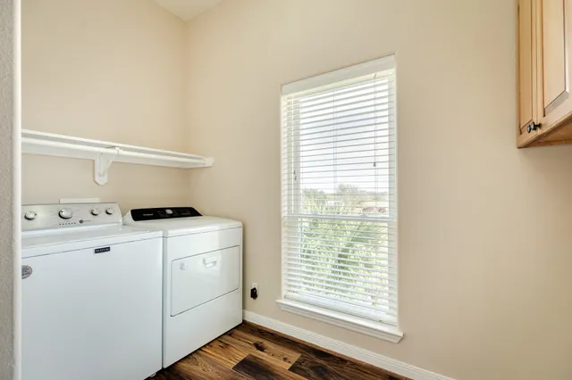a view of washer and dryer with white cabinets