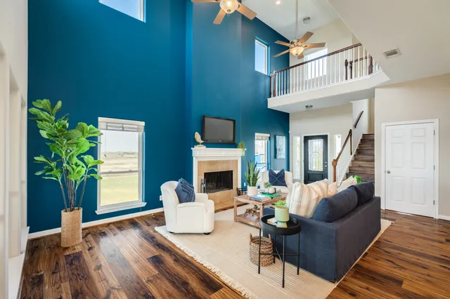 a living room with furniture a fireplace and a potted plant