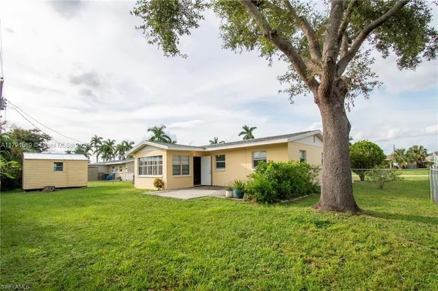 a view of a house with garden and a tree