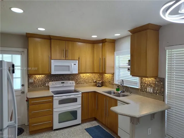 a kitchen with kitchen island stainless steel appliances a sink stove and refrigerator