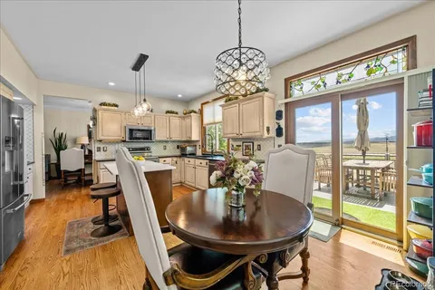 a view of a dining room with furniture a chandelier and wooden floor