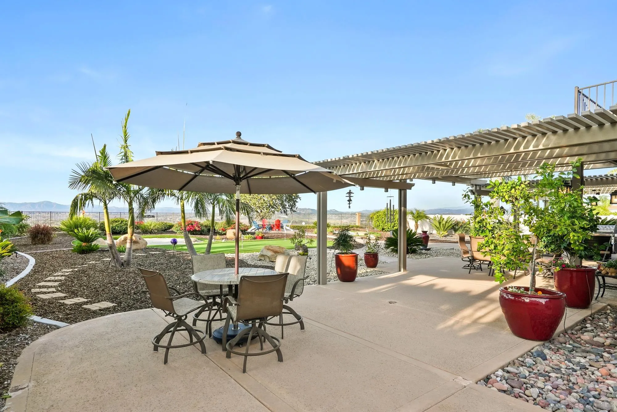 5028 Avenida De La Plata Oceanside, CA 92057 - Photo 43 of 68 a view of patio with a table and chairs under an umbrella