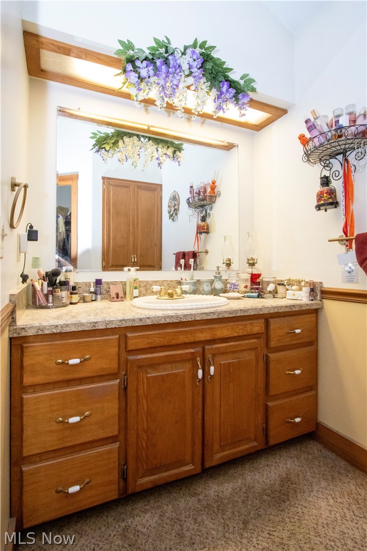 1043 North Honeytown Road Wooster, OH 44691 - Photo 12 of 46 Wood-finish vanity with multiple drawers and cabinet storage, under-mount sink, and a speckled countertop