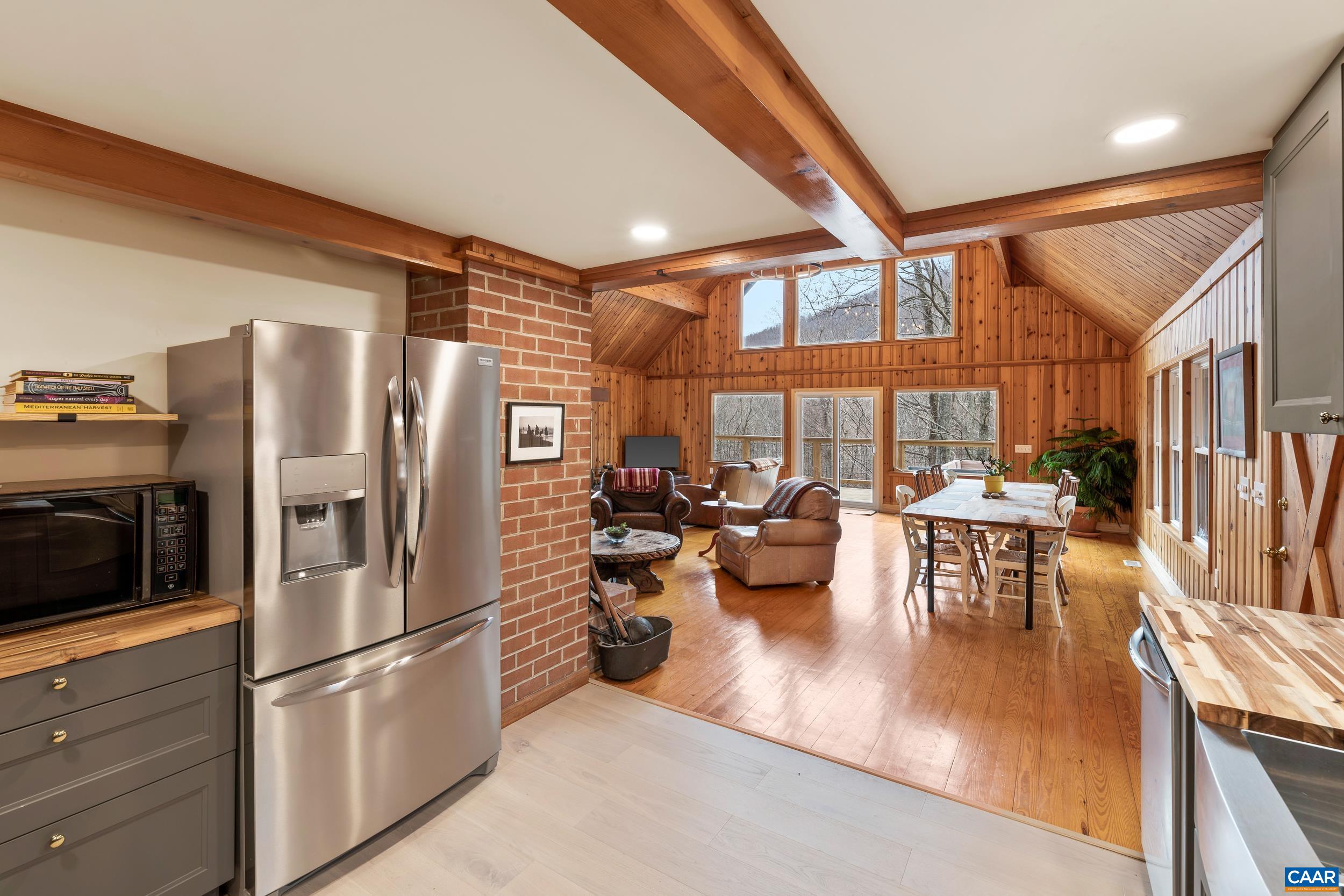 4496 Weakley Hollow Road Syria, VA 22743 - Photo 13 of 37 a kitchen with stainless steel appliances granite countertop a refrigerator a stove and a dining table with wooden floor