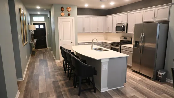 a kitchen with kitchen island a refrigerator stove microwave and cabinets