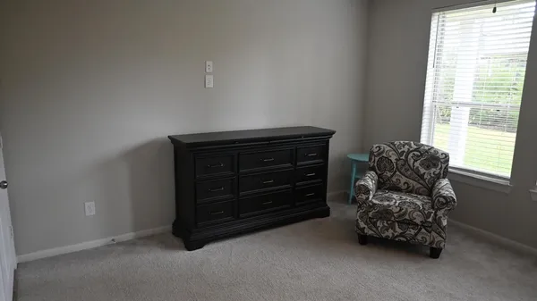 a room with a dresser and a window