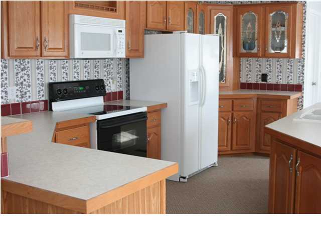 490 Long Road DeFuniak Springs, FL 32433 - Photo 13 of 22 a kitchen with stainless steel appliances a refrigerator a stove and white cabinets