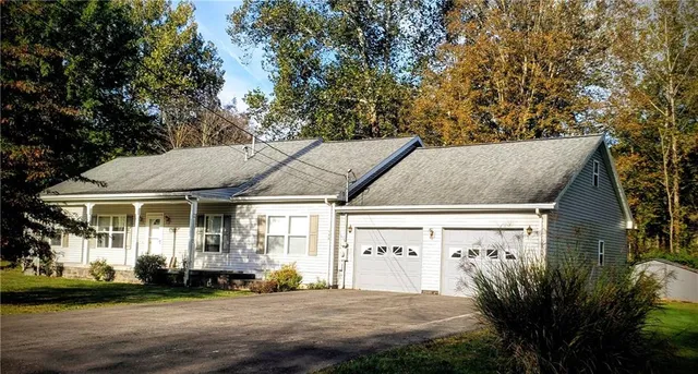 a view of a white house with a large tree