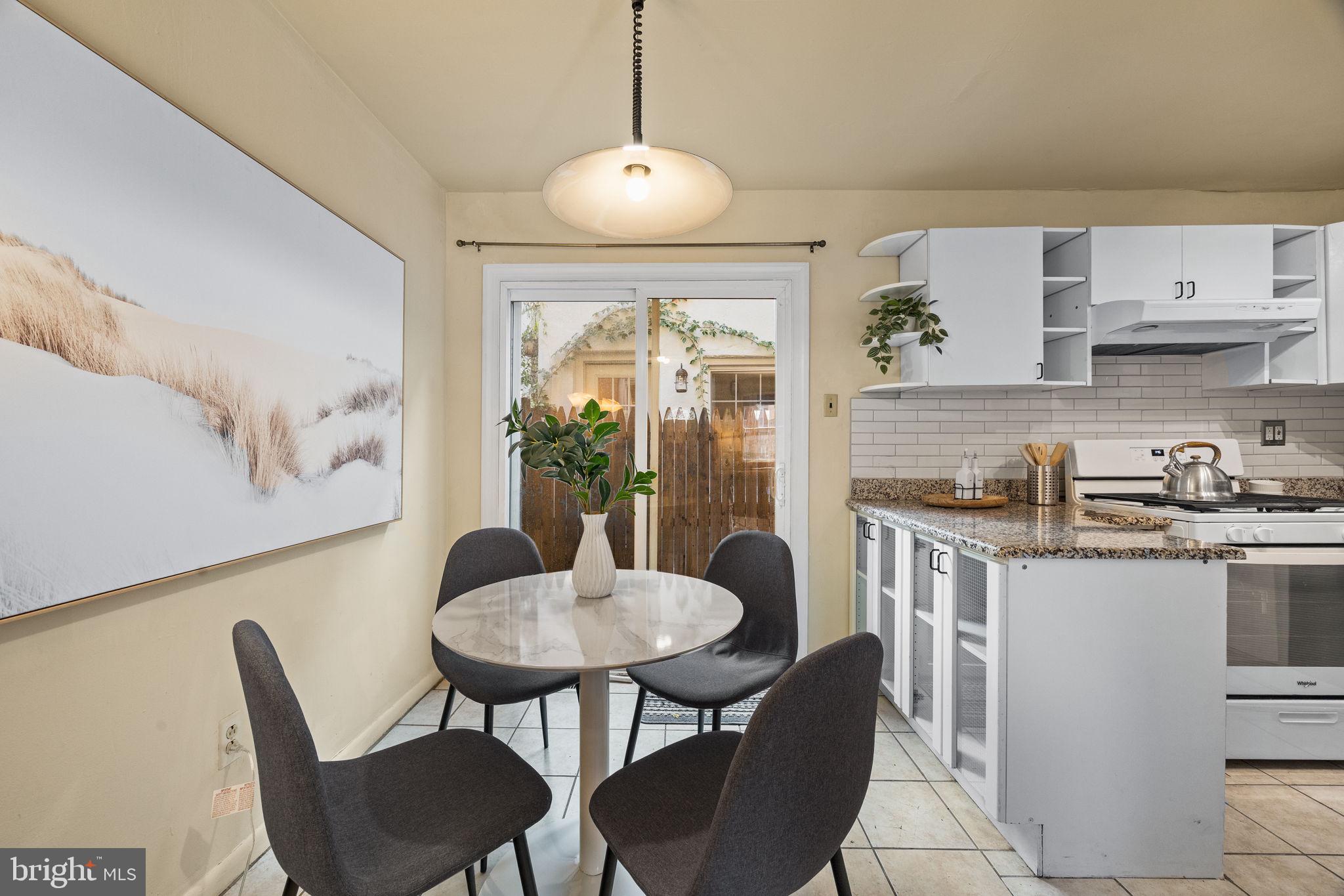 1905 Rodman Street Philadelphia, PA 19146 - Photo 7 of 22 a kitchen with stainless steel appliances granite countertop a table and chairs in it