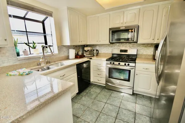 a kitchen with a sink appliances and a large window
