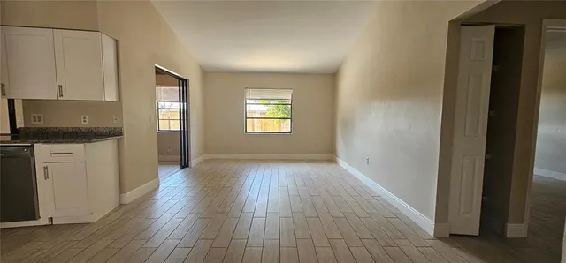 a view of a kitchen and window with wooden floor