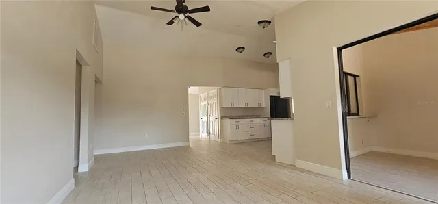 a kitchen with a refrigerator and white cabinets
