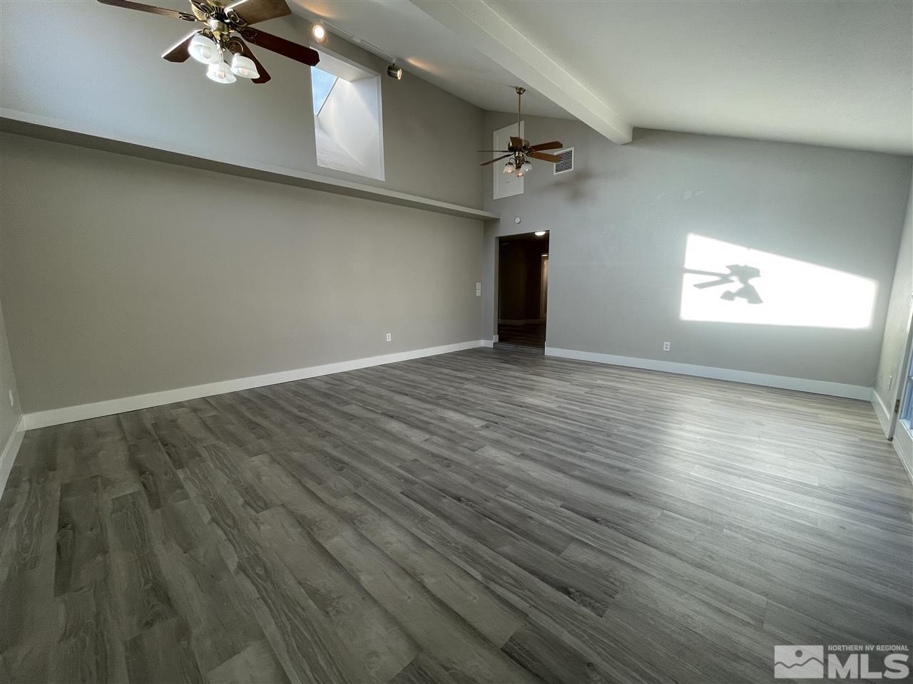 1440 Upton Way Sparks, NV 89431 - Photo 11 of 28 an empty room with wooden floor chandelier fan and windows