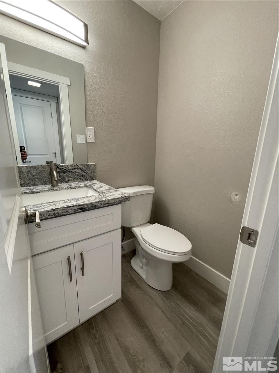 1440 Upton Way Sparks, NV 89431 - Photo 19 of 28 a bathroom with a granite countertop toilet sink and mirror