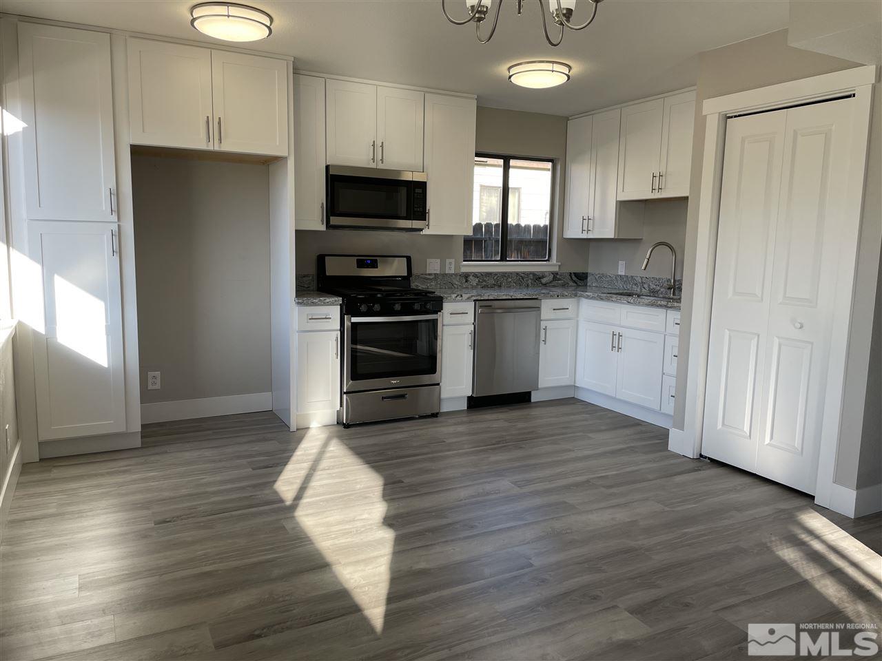 1440 Upton Way Sparks, NV 89431 - Photo 2 of 28 a kitchen with granite countertop a refrigerator and a stove top oven