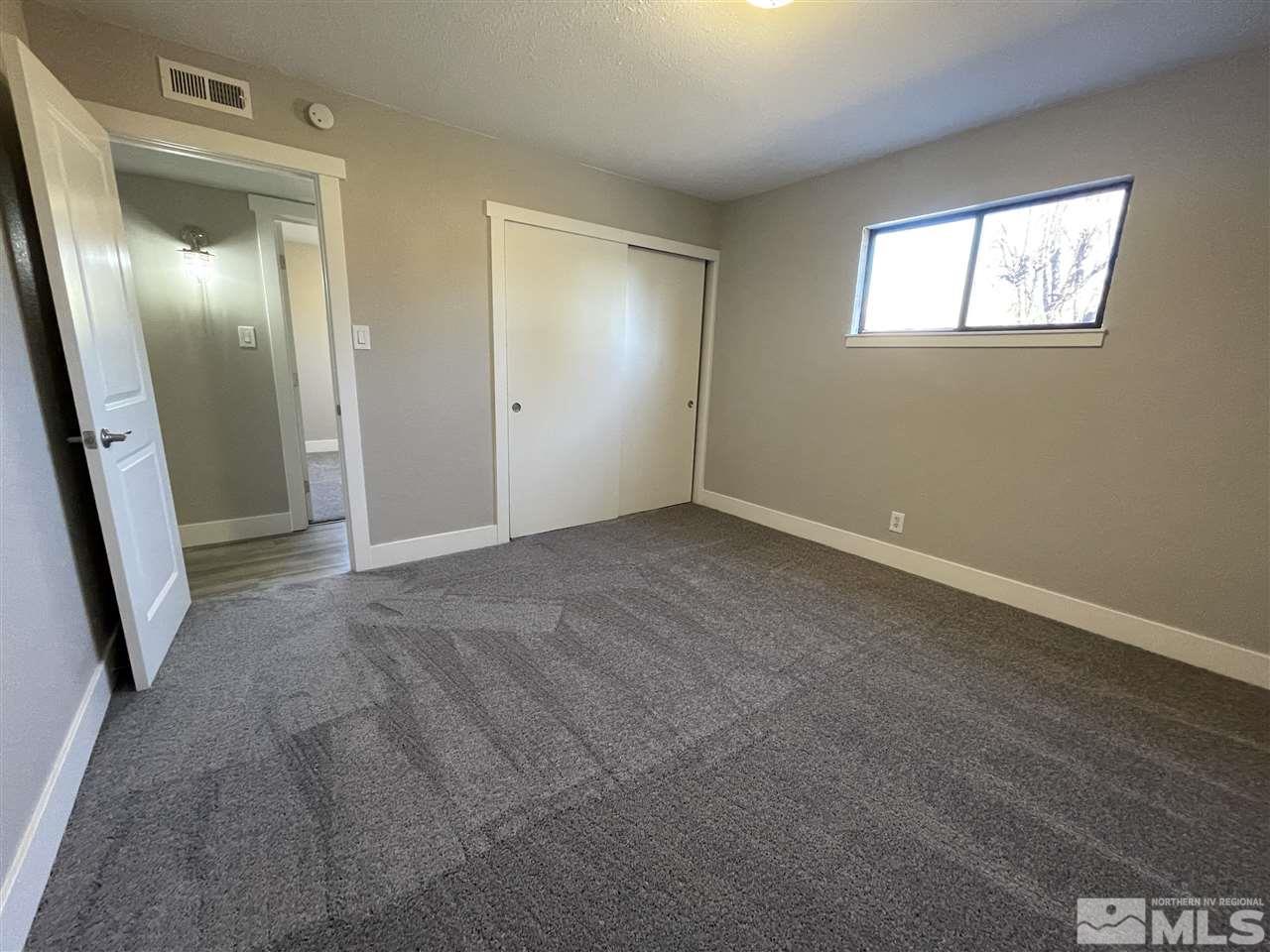 1440 Upton Way Sparks, NV 89431 - Photo 23 of 28 an empty room with windows and wooden floor