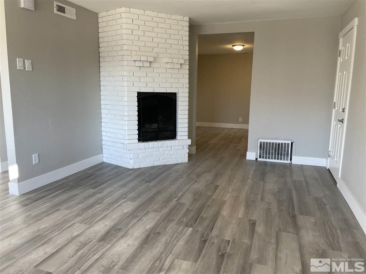 1440 Upton Way Sparks, NV 89431 - Photo 6 of 28 a view of an empty room with wooden floor and a fireplace