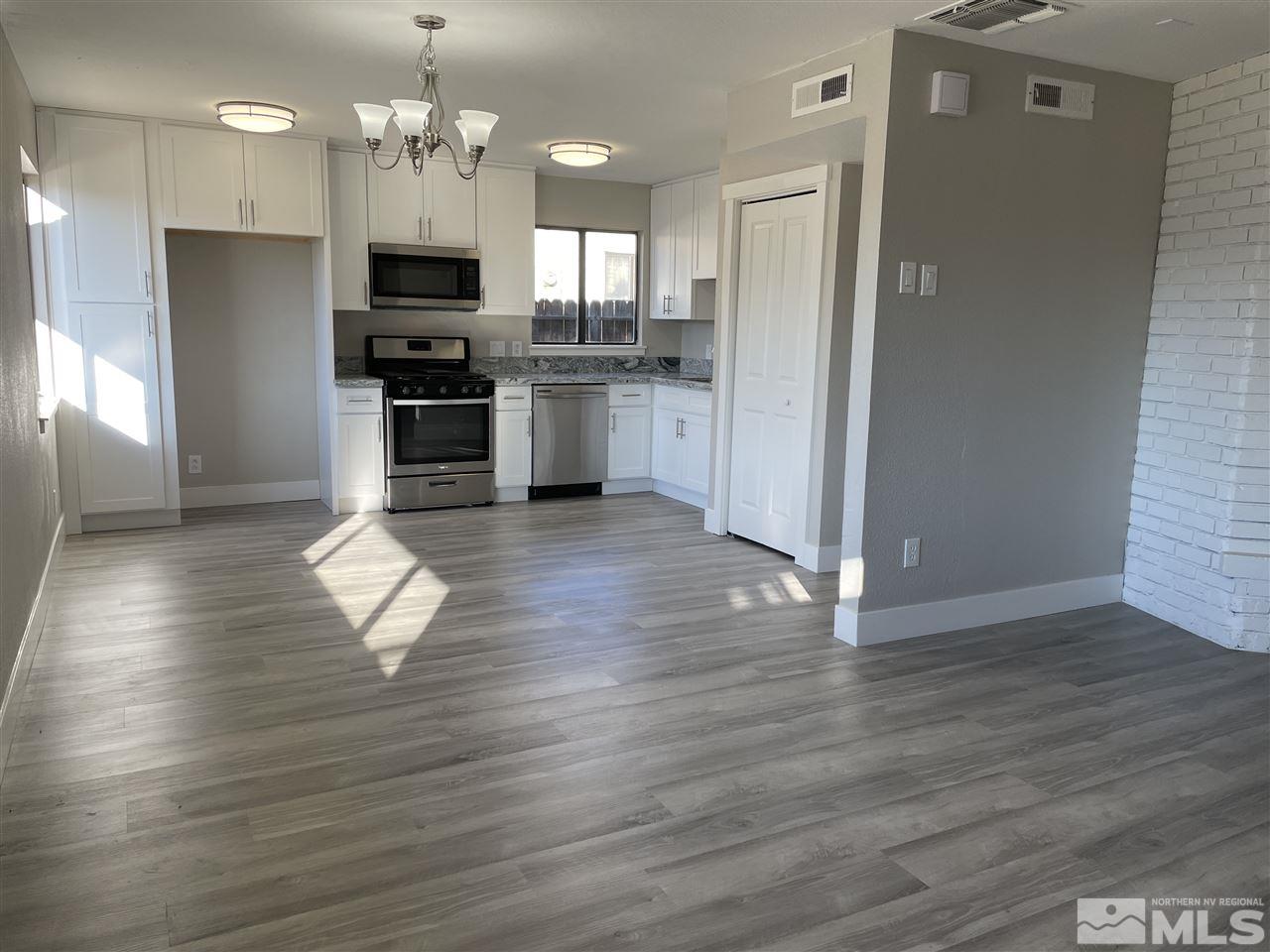 1440 Upton Way Sparks, NV 89431 - Photo 7 of 28 a kitchen with stainless steel appliances granite countertop a refrigerator a stove oven a sink dishwasher and a refrigerator with wooden floor