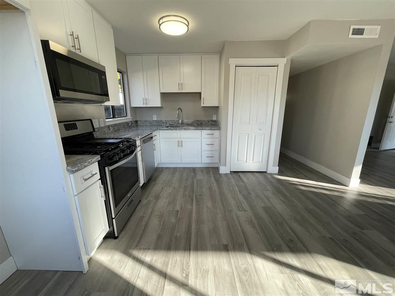 1440 Upton Way Sparks, NV 89431 - Photo 8 of 28 a kitchen with wooden floors and stainless steel appliances