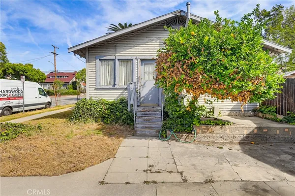 a view of a house with a yard and potted plants