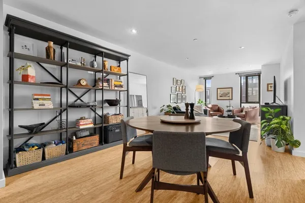 a view of a workspace and dining room with furniture wooden floor and a flat screen tv