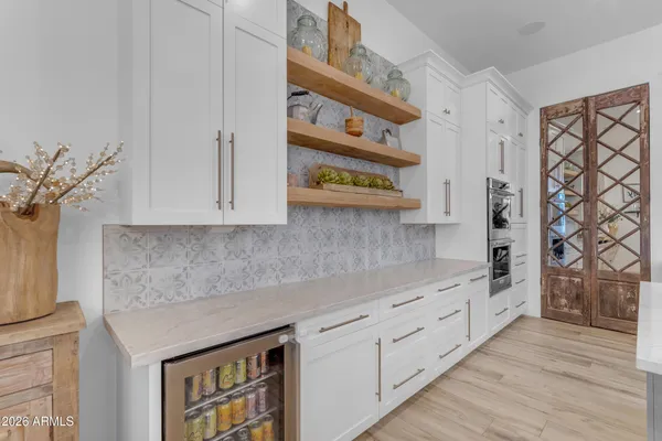 a view of a patio with table and chairs under an umbrella next to a yard
