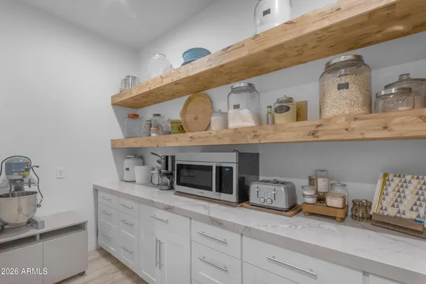 a view of a terrace with a barbeque and wooden fence
