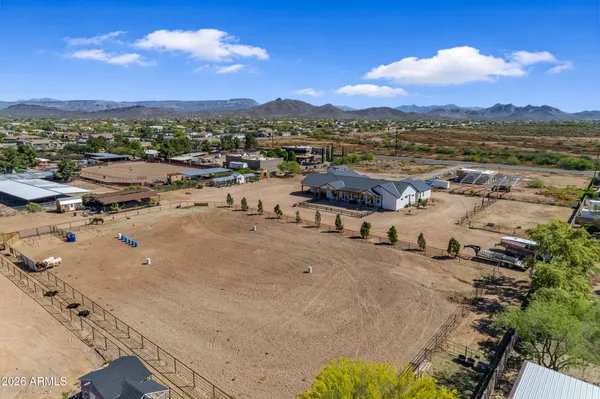 a living room with furniture kitchen view and a wooden floor