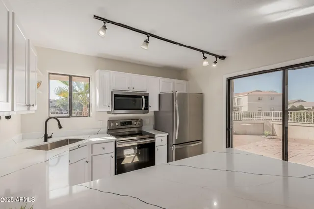a kitchen with stainless steel appliances a refrigerator sink and microwave