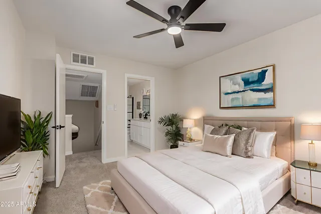 a bedroom with a large bed and a chandelier