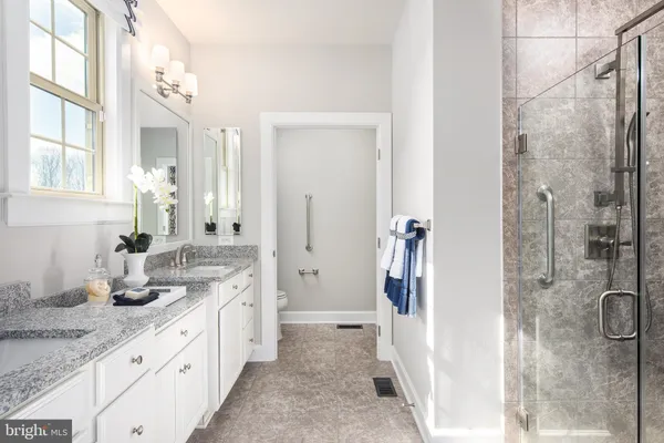 a spacious bathroom with a granite countertop sink mirror and shower