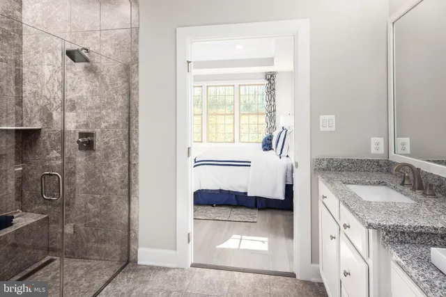 a bathroom with a granite countertop sink and a mirror