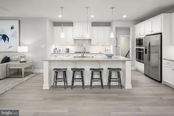 a kitchen with stainless steel appliances granite countertop a table chairs sink refrigerator and microwave