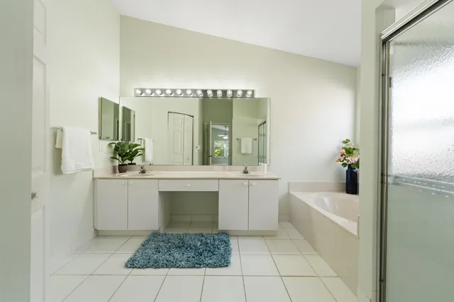 a bathroom with a bathtub a sink and a large mirror