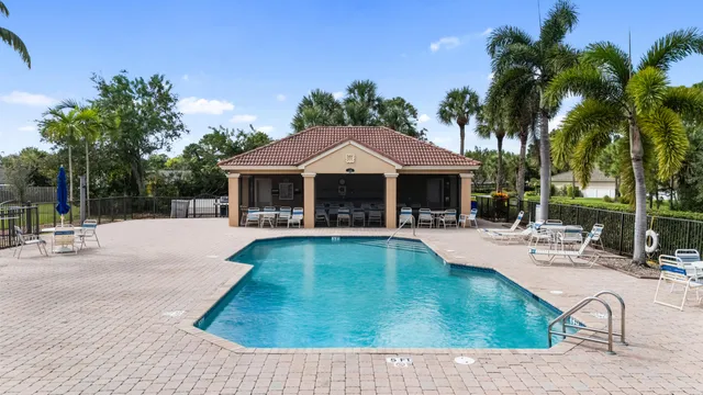 a view of house with swimming pool and outdoor seating