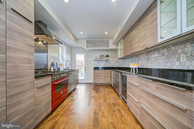 a kitchen with stainless steel appliances granite countertop a sink stove and wooden floor